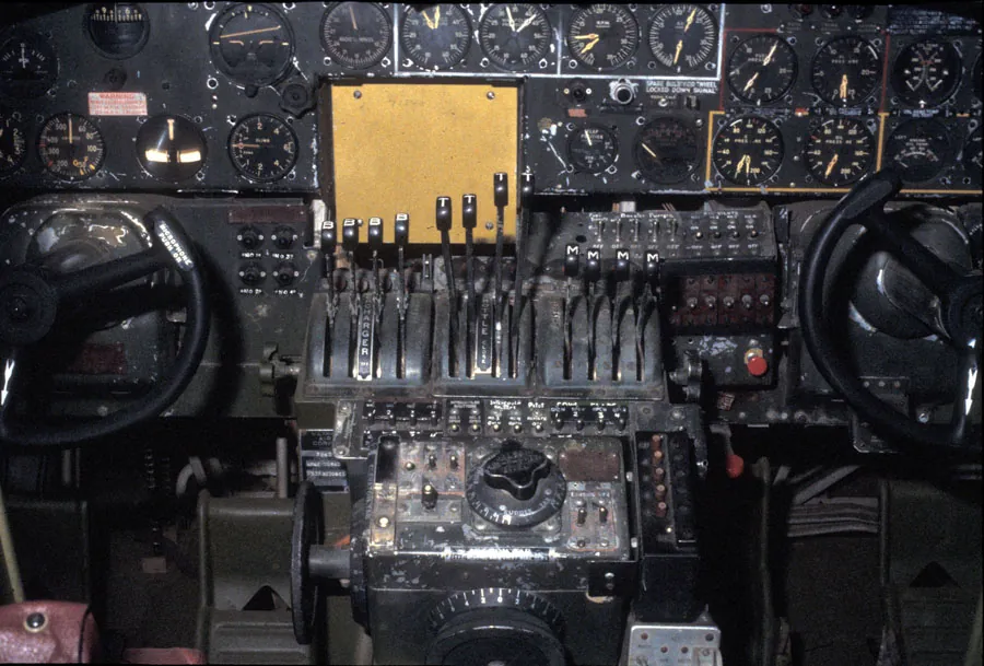 The image shows an aircraft panel with lots of dial indicators, some levers and two wheels.