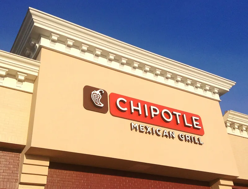 The Chipotle name and logo is on a building.