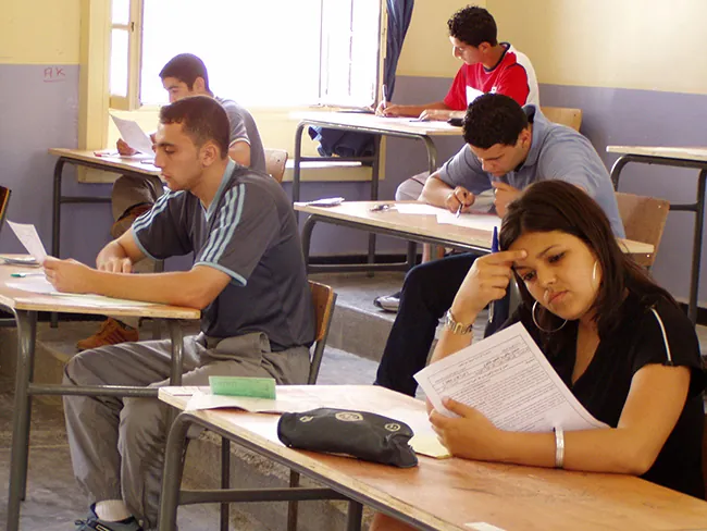 A photo shows students writing exam in an examination hall.