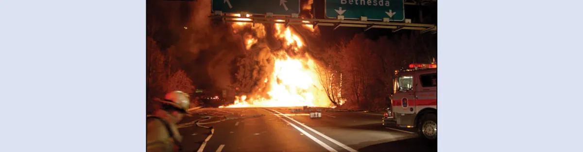 Una imagen muestra una gran bola de fuego ardiendo en una carretera. Un camión de bomberos y un bombero aparecen en primer plano.