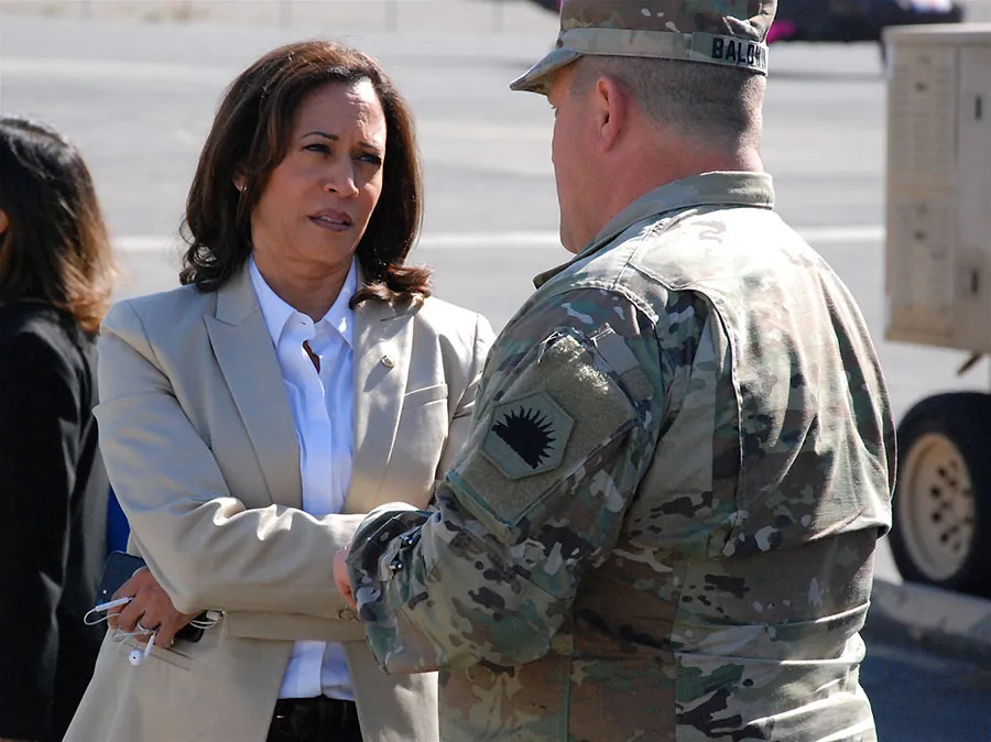 Kamala Harris speaks to a military commander.
