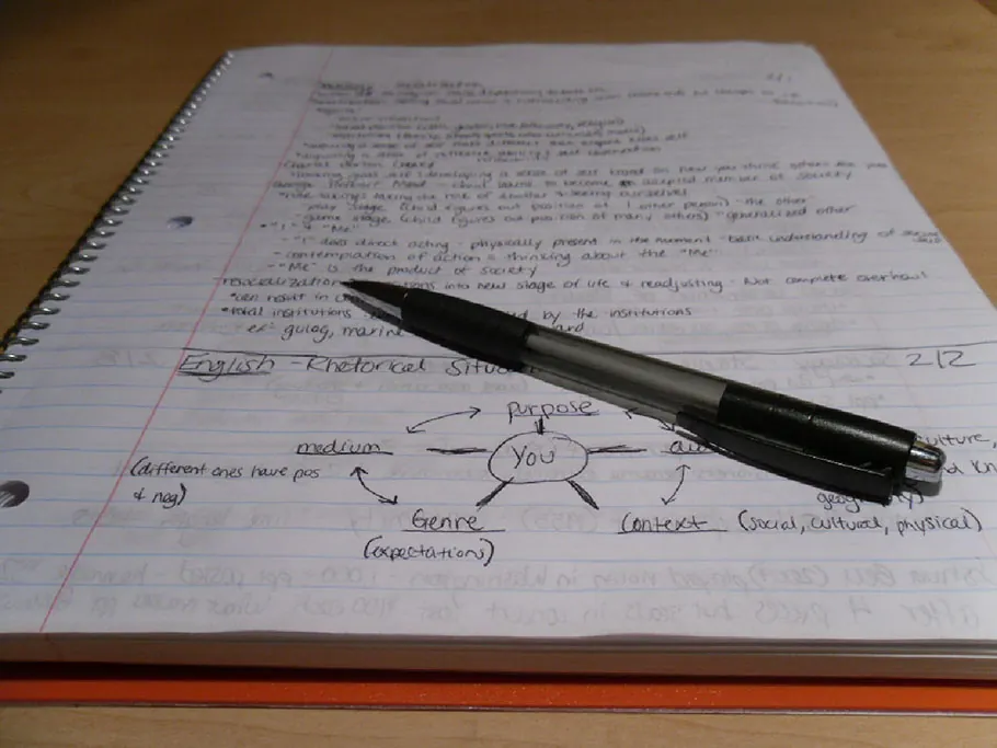 A pen placed atop a student’s notebook, with the page full of handwritten notes and a diagram.