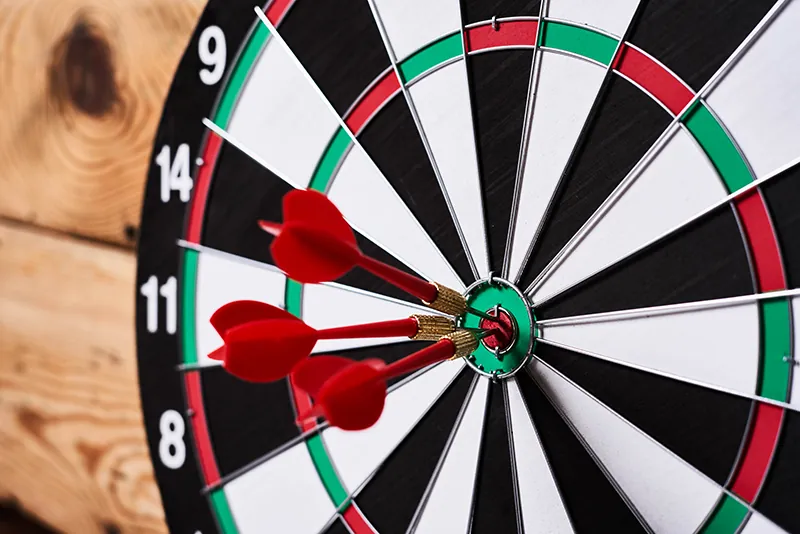 Three darts are in the bullseye of a dartboard.