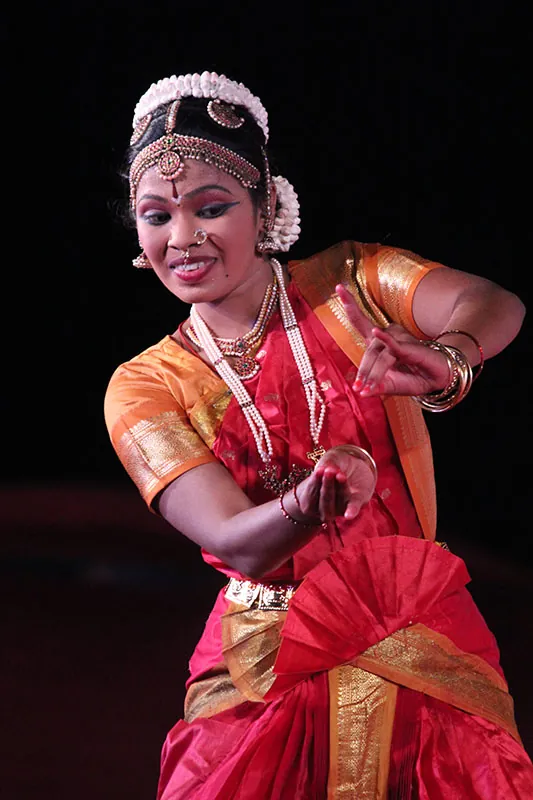 A dancer performs a Bharatnatyam dance at a dance festival, using facial expressions and gestures.
