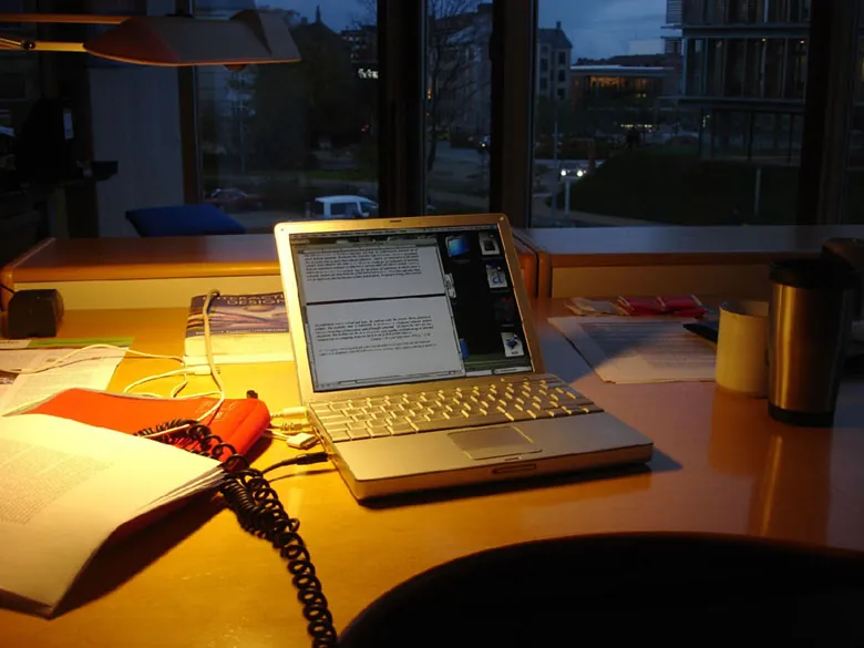 A laptop sits on a work table displaying a word document.