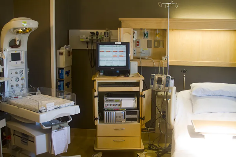 A hospital room with many pieces of medical equipment.