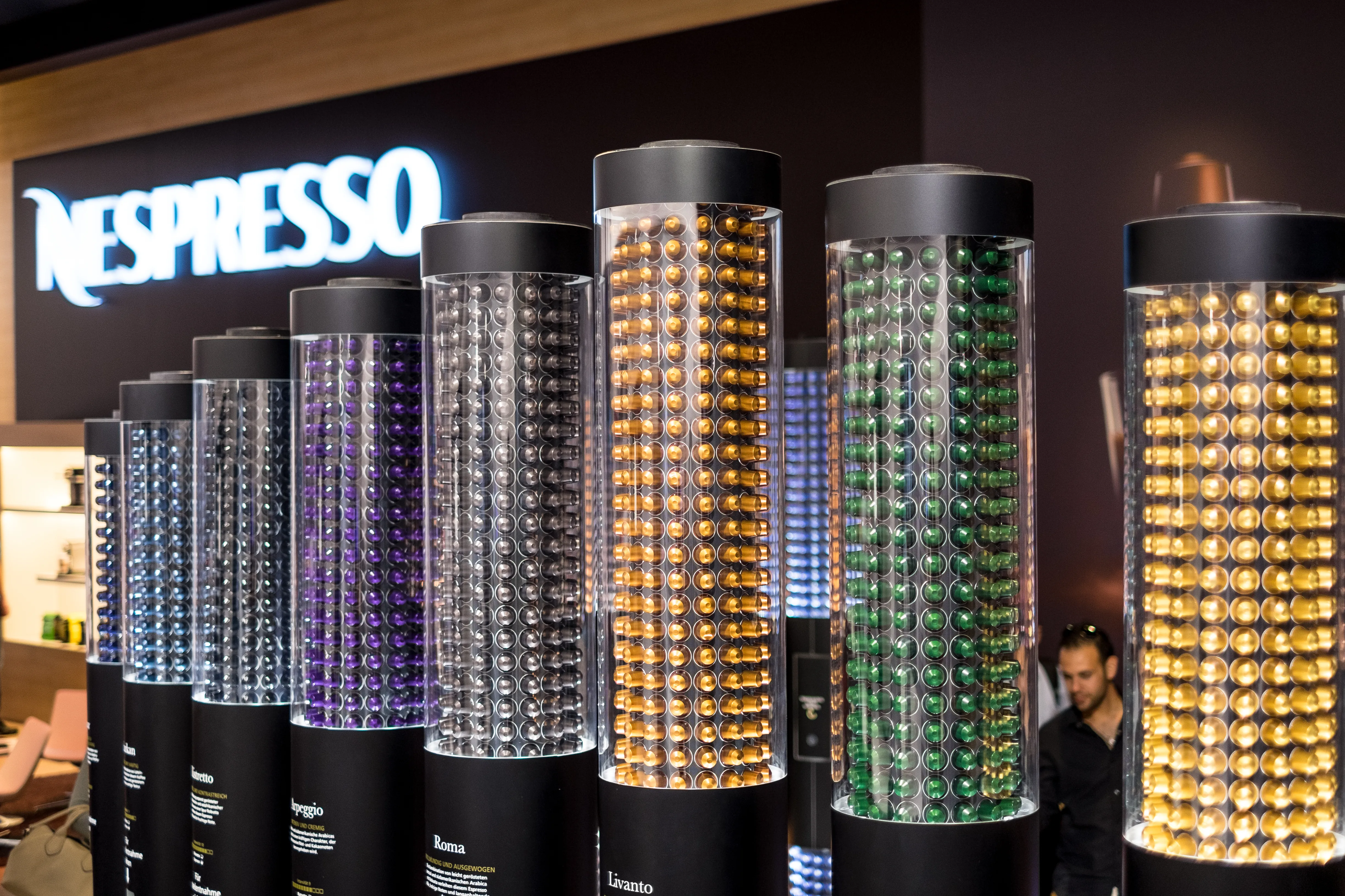 A photograph shows a display of all the small, plastic coffee pods made by Nespresso.