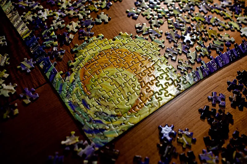 A photo shows the overhead view of an incomplete jigsaw puzzle with hundreds of pieces.