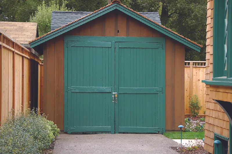 This image shows a small wooden garage in a backyard.