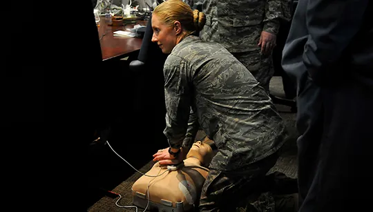 Air Force officials practice using an automated external defibrillator (AED). Electric potential energy is stored in the defibrillator unit and sent to resuscitate the patient.