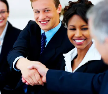 A photo shows two managers shaking hands during a meeting.