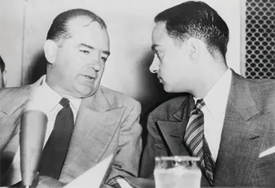 A photograph shows Joseph McCarthy and Roy Cohn engaged in a quiet conversation.