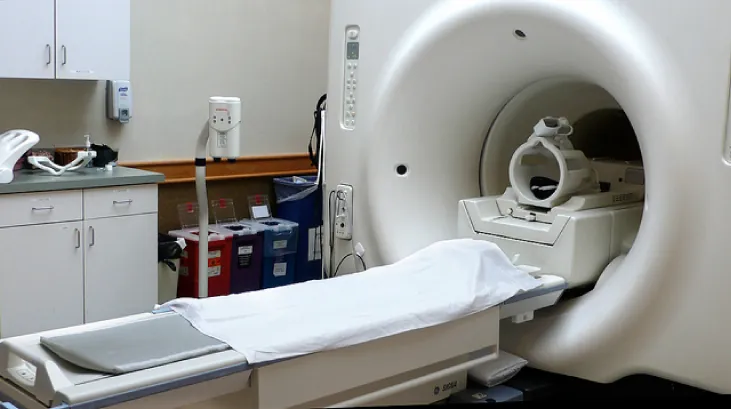 Zdjęcie ukazuje system MRI. Składa się on z cylindrycznej cewki, która jest generatorem silnego pola magnetycznego.