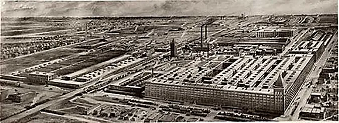 A black-and-white photo shows an aerial view of the Hawthorne Works, a large factory complex consisting of several buildings.