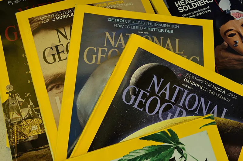 A pile of National Geographic magazines is shown.
