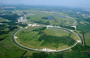 An aerial view of the Fermi National Accelerator Laboratory is shown.