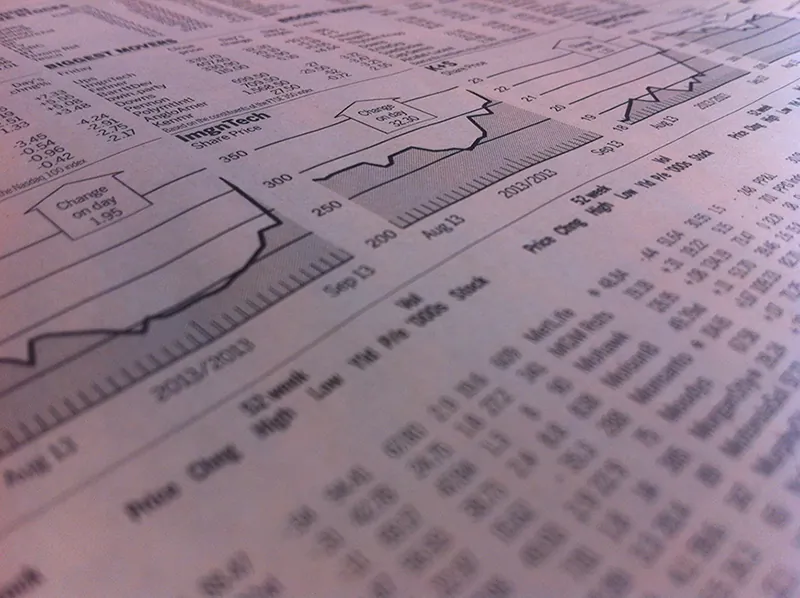 A close up view of a newspaper showing stock price changes.
