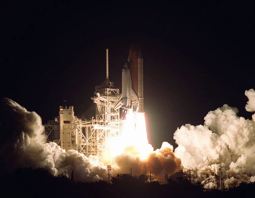 A space shuttle rocket is being launched and is burning propellant.