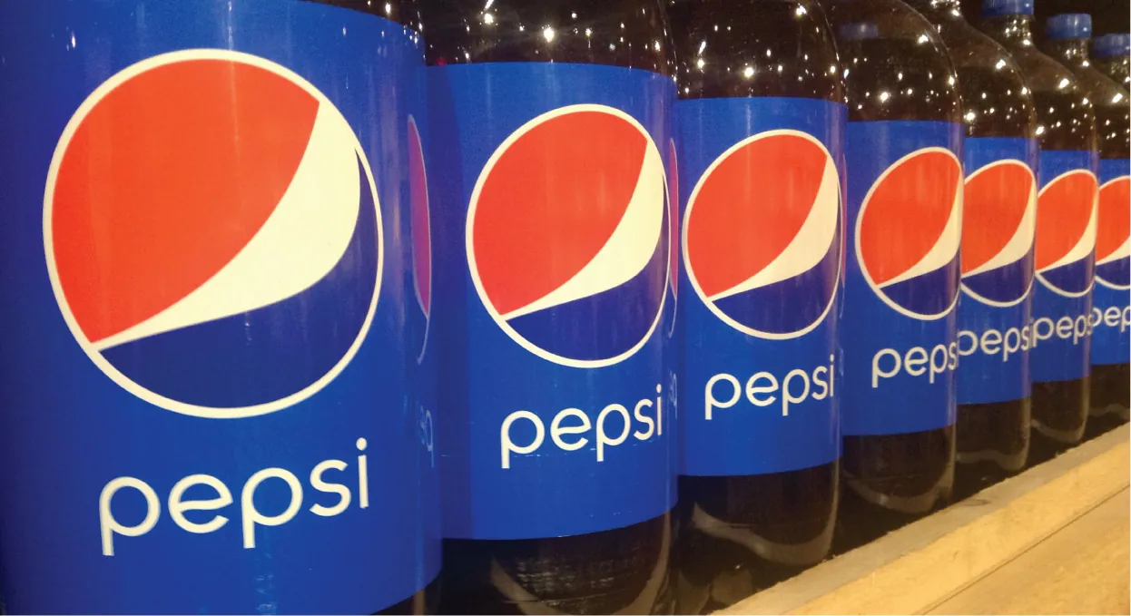 Several bottles of Pepsi sit on a shelf.