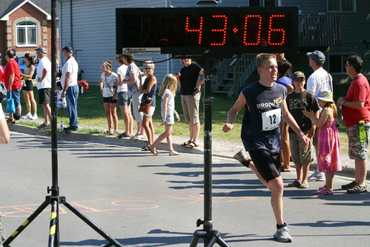 A photo of the finish of a foot race with the time �43:06� shown for the racer crossing the finish line.