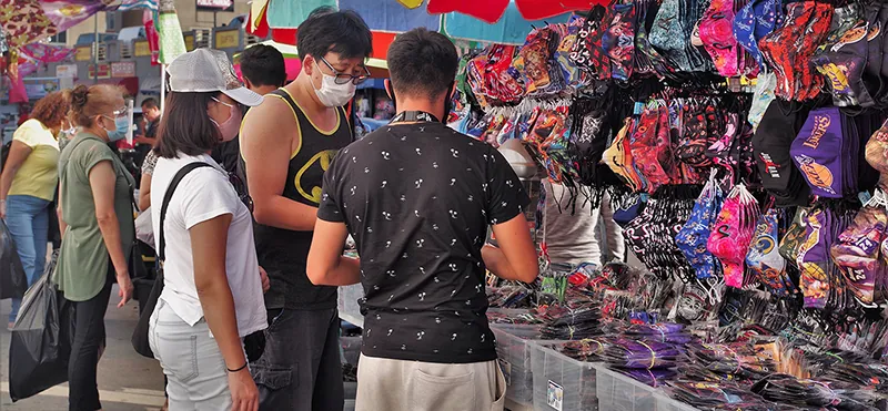 People are wearing face masks at an open market.
