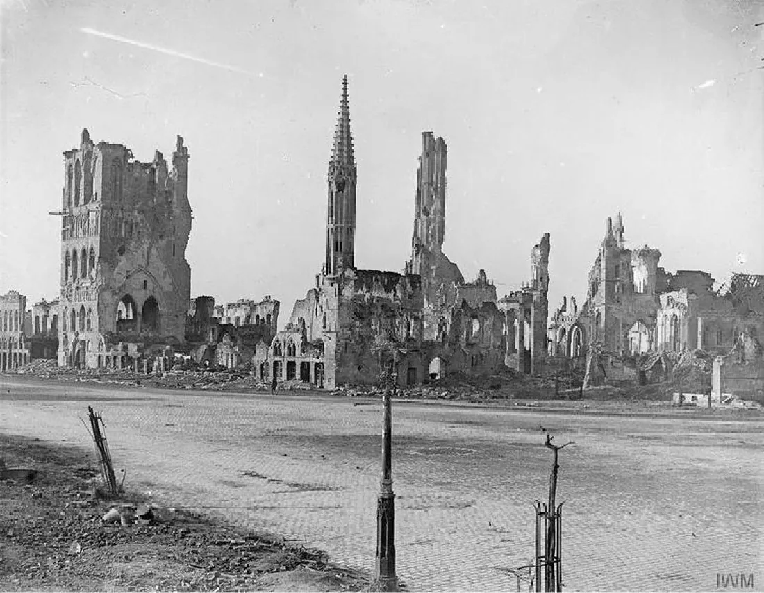 The photograph shows demolished and burned buildings.