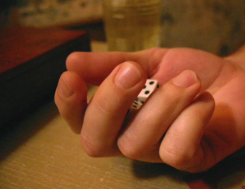 A close-up of a hand holding two dice.
