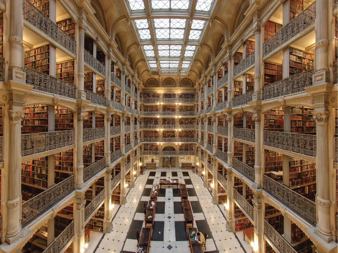 A view of the central hall of a large library with multiple stories and what appears to be thousands of books in view.