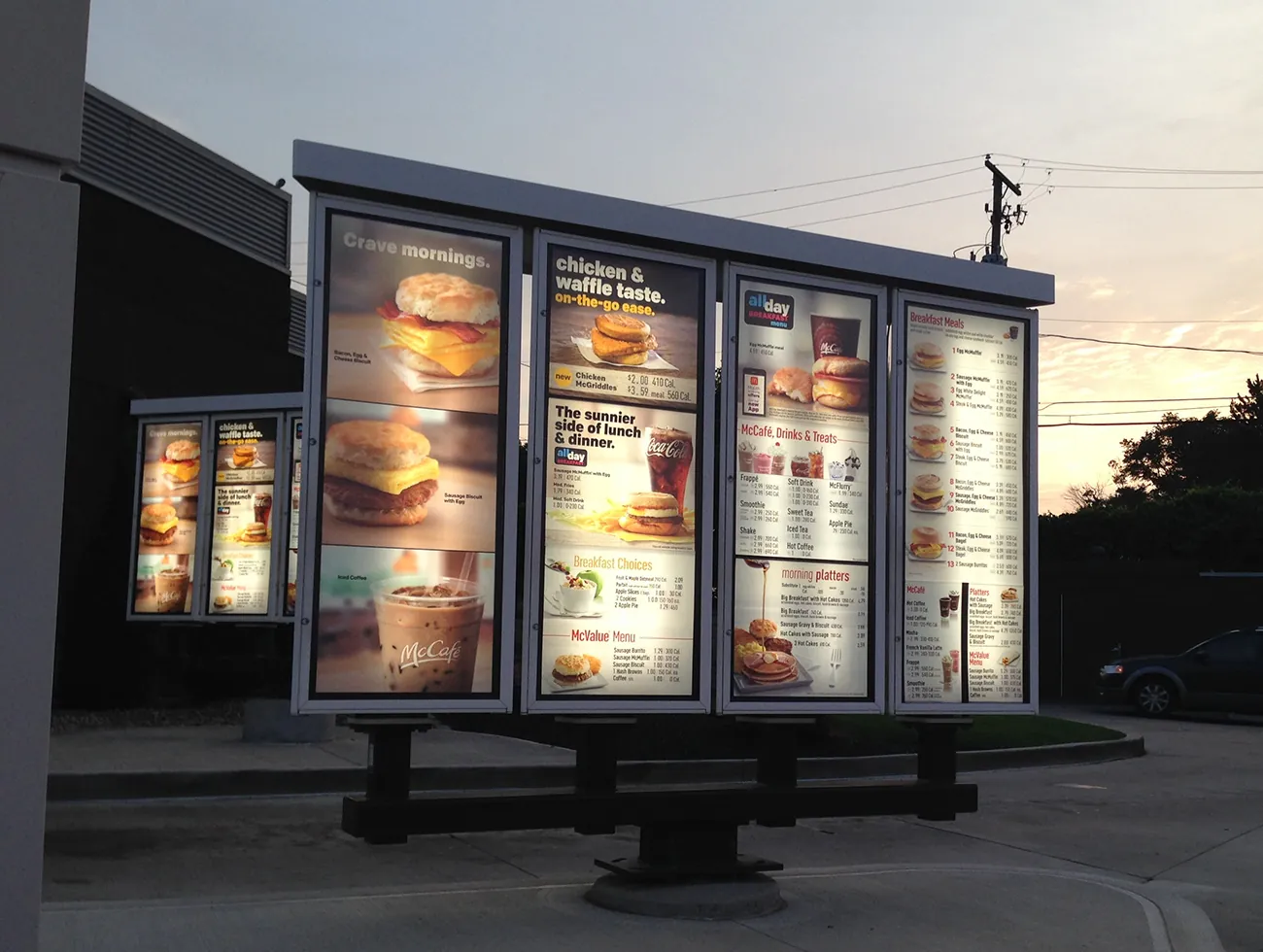 A photo shows a McDonald’s drive-through menu put outside the restaurant. The pages of the menu are shown placed in a large lit-up glass display case.