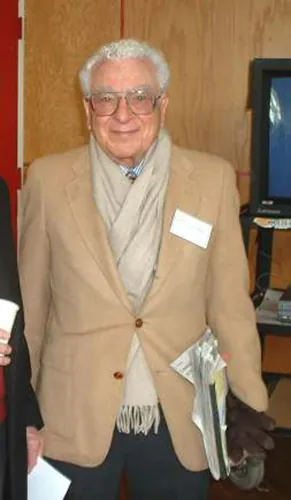 The image shows a picture of physicist Murray Gell Mann, who looks like a pleasant white-haired gentleman.