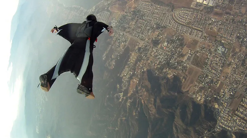 Una persona que cae en wingsuit, el cual sirve para reducir la velocidad vertical de la caída de un paracaidista.