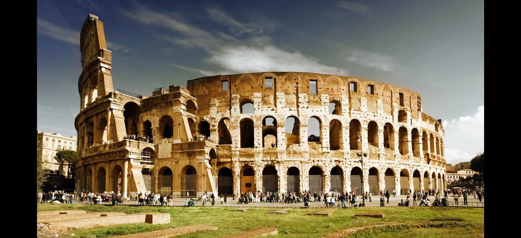 A photograph of the Roman Colosseum with tourists surrounding it.