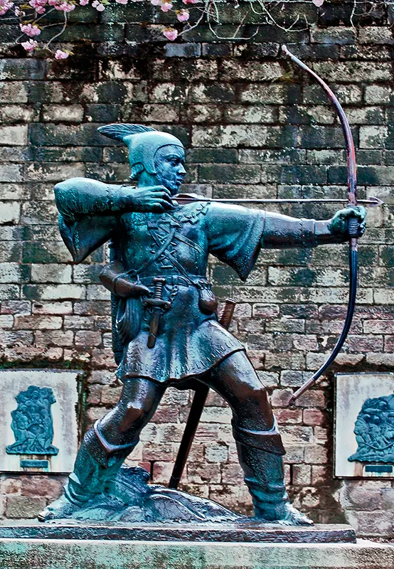 A modern statue shows Robin Hood placing an arrow in a bow to shoot.
