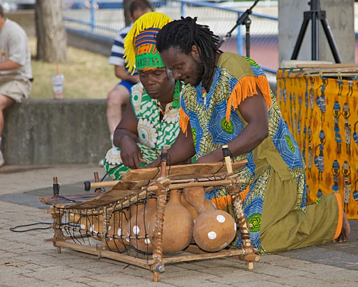 Photograph of two musicians playing on a marimba.