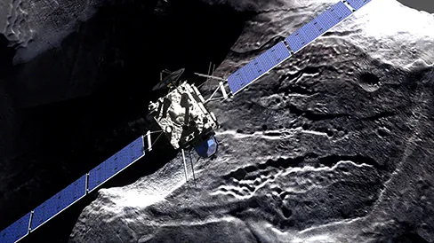 An image of the Rosetta spacecraft is shown. It has large solar panels and is hovering over a comet.