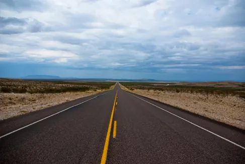 A picture of an empty highway in the desert.