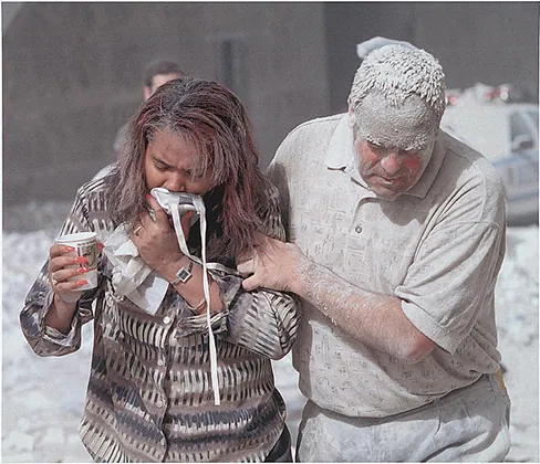 A photograph shows two people covered in dust; one appears to be helping the other.