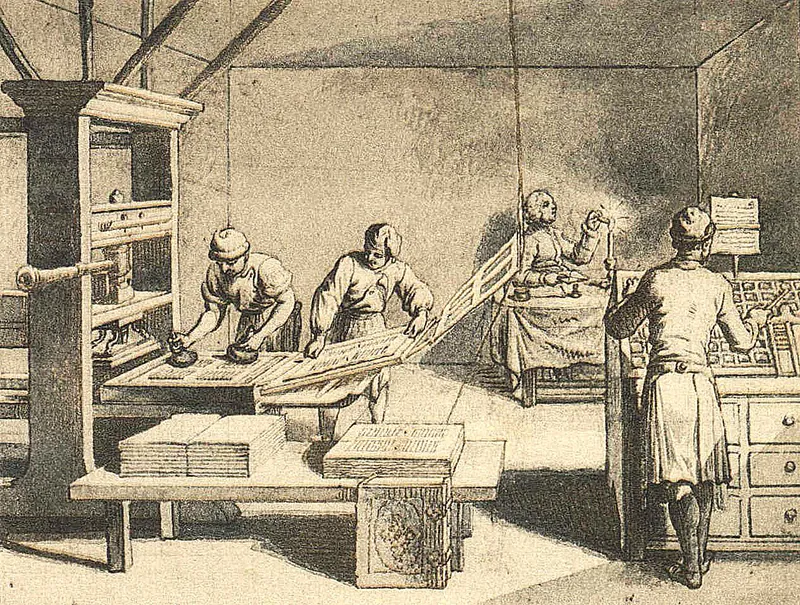 A drawing of several people setting type and operating a Gutenberg Printing press. Broad sheets of printed papers are piled on a table in the foreground.