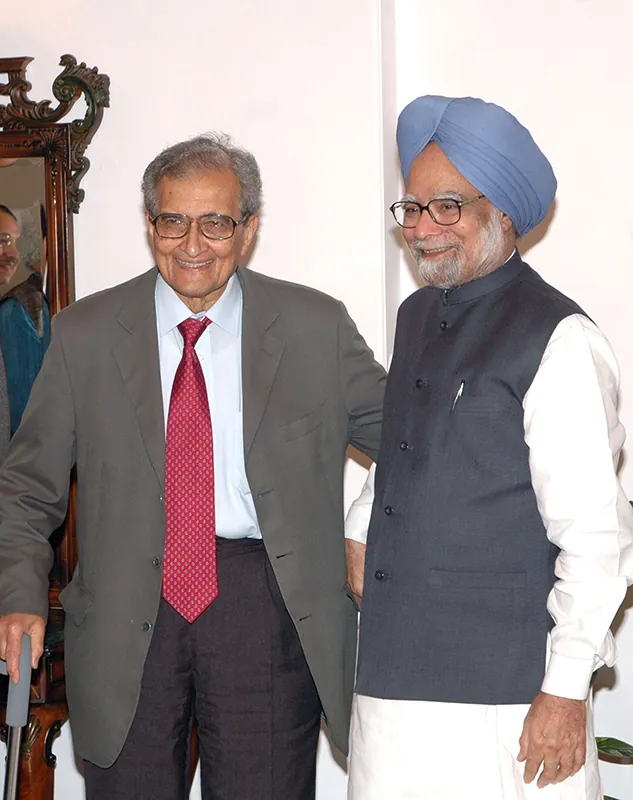 A photograph shows Amartya Kumar Sen standing with India's 13th prime minister, Dr. Manmohan Singh.