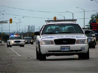 Police car driving on multi lane road toward camera