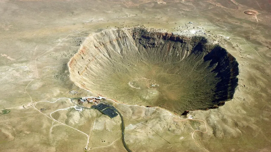 Zdjęcie lotnicze krateru Barringera. Nad brzegiem krateru widoczna grupa zabudowań, o rozmiarach małych w porównaniu do średnicy krateru.