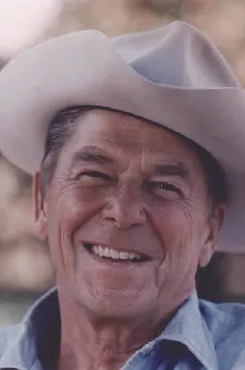 A photo of Ronald Reagan wearing a cowboy hat and denim shirt.