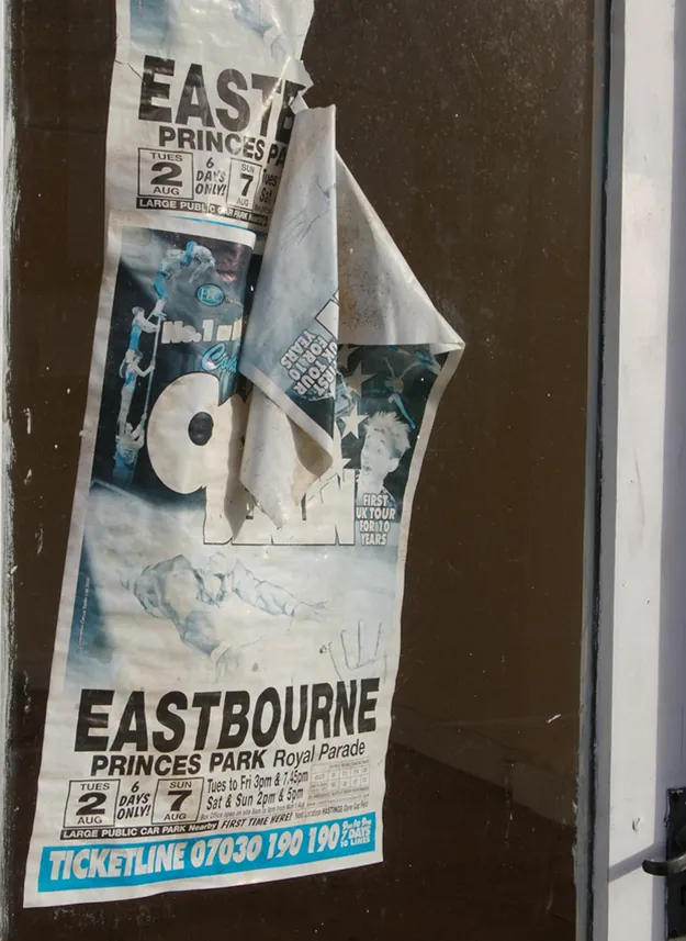 Photograph of a worn-out movie advertisement poster on a wall.