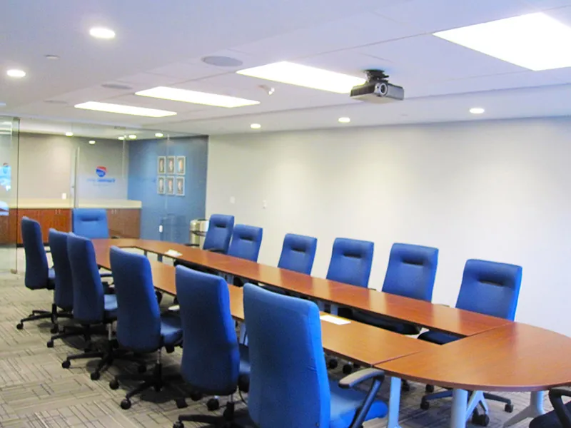 A corporate board room with approximately ten chairs placed around a long table.