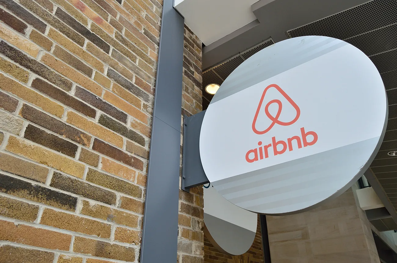 A photo shows the signature and logo of “Airbnb” company at the entrance of an apartment building.