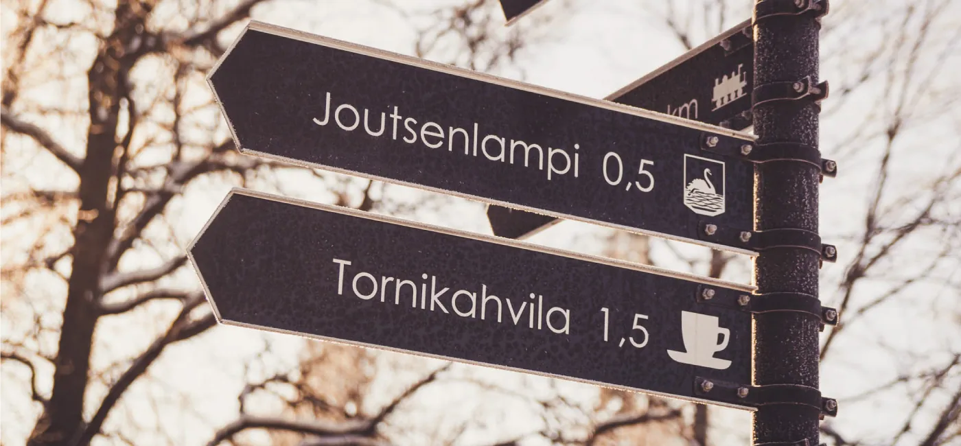 A road sign written in Finnish that reads Joutsenlampi 0,5; Tornikahavila 1,5.