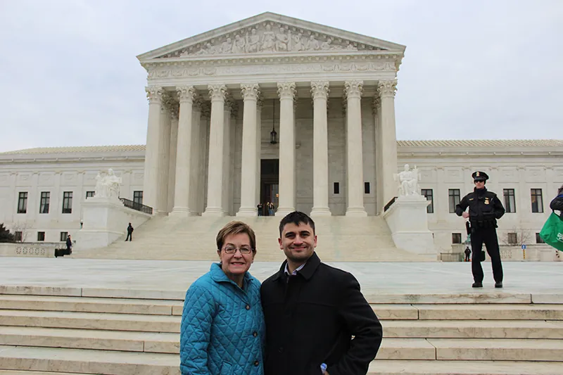 Ohio Congressperson Marcy Kaptur stands in front of the Supreme Court with voter Larry Harmon, who  was purged from the voter rolls for not voting since 2008. Asecurity guard is also pictured.
