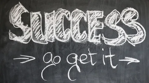 Czarna tablica, na której napisane jest: success, go get it.