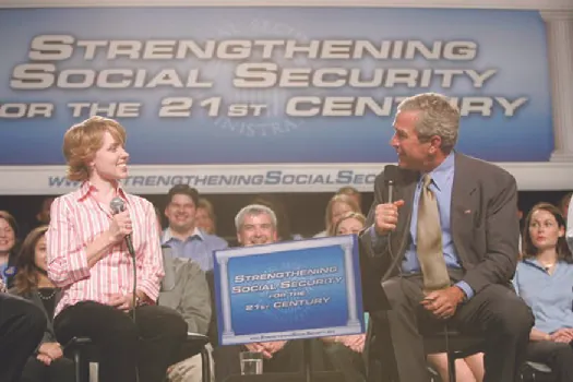 A photo of George W. Bush speaking at an event. The banner behind him says “Strengthening Social Security for the 21st Century.”