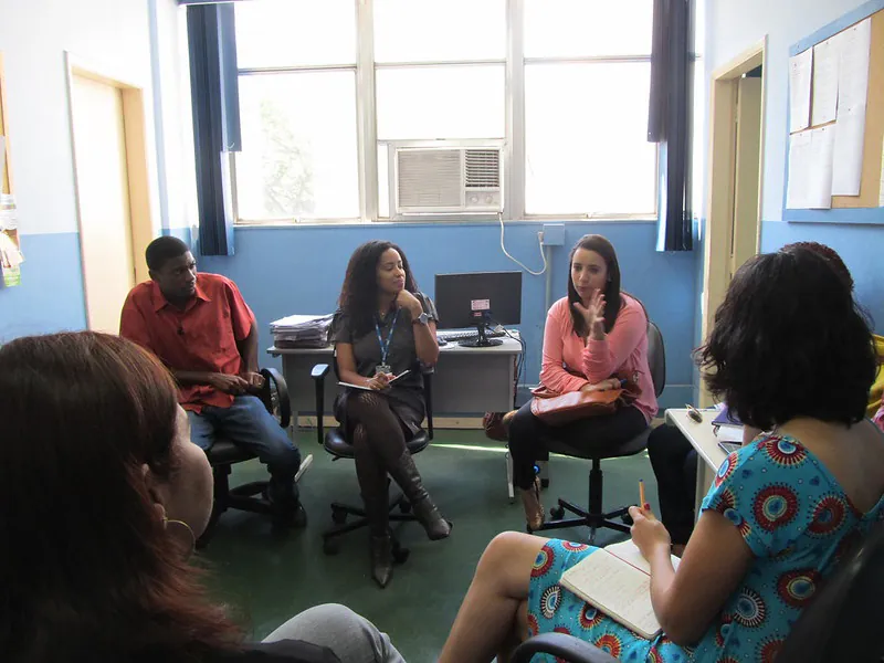 A diverse group of students sits in a circle in a classroom to share ideas.